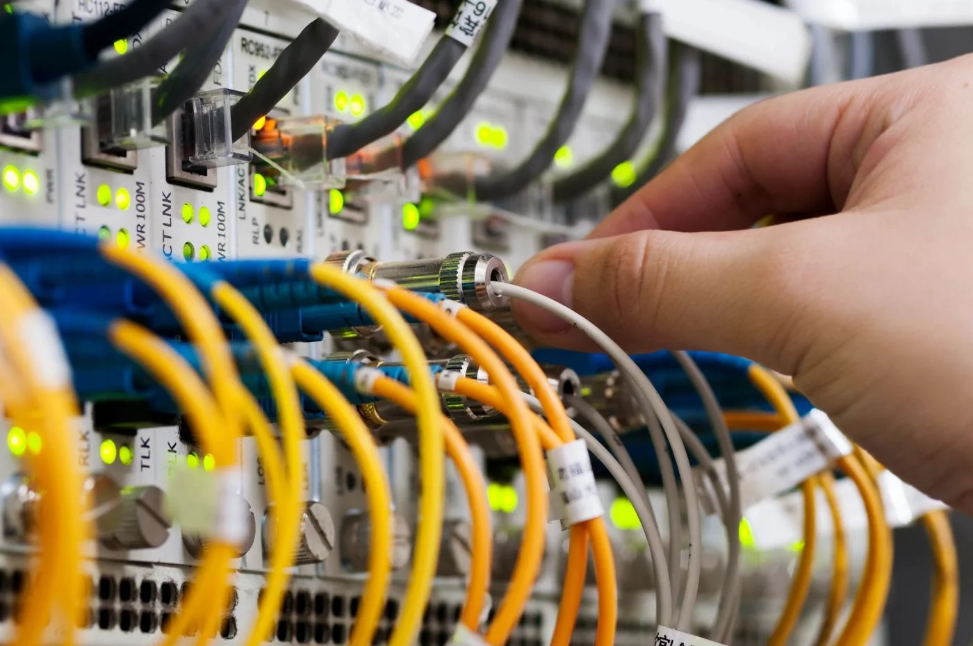Hands connecting cables to network equipment